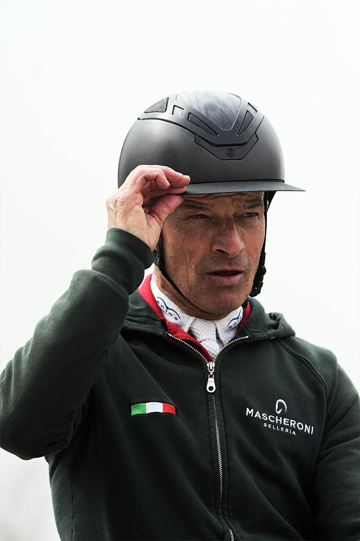 pius mentre si sistema la visiera del casco suomy in sella al suo cavallo